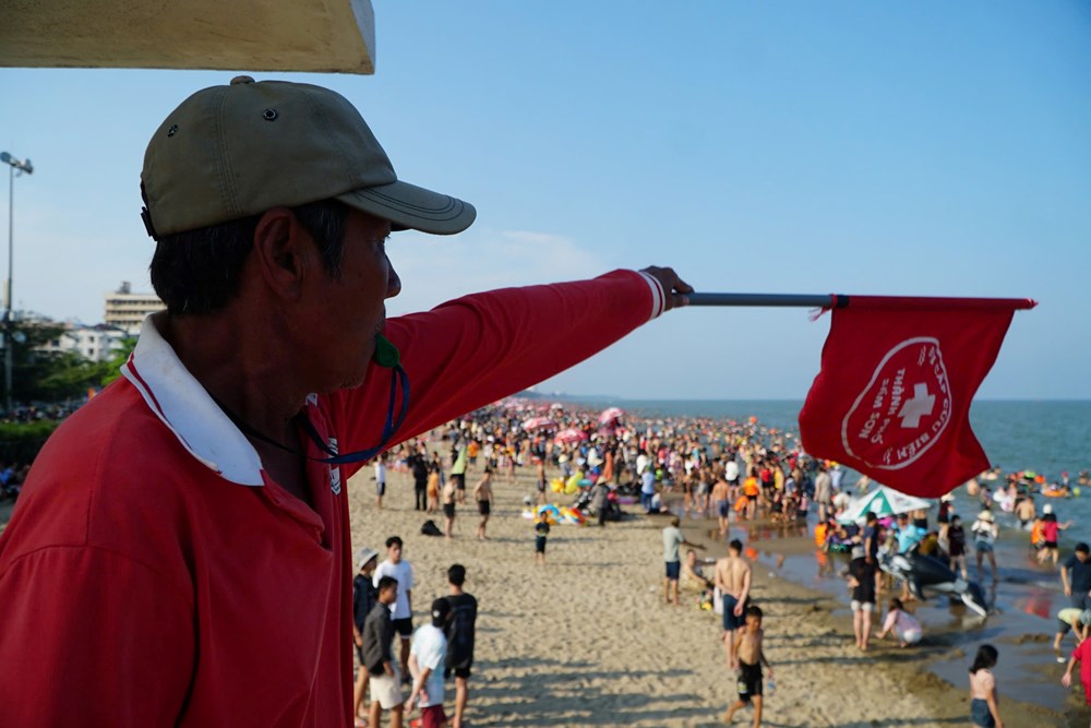 Lực lượng chức năng l&agrave;m nhiệm vụ nhắc nhở du kh&aacute;ch tắm biển kh&ocirc;ng ra khu vực nguy hiểm