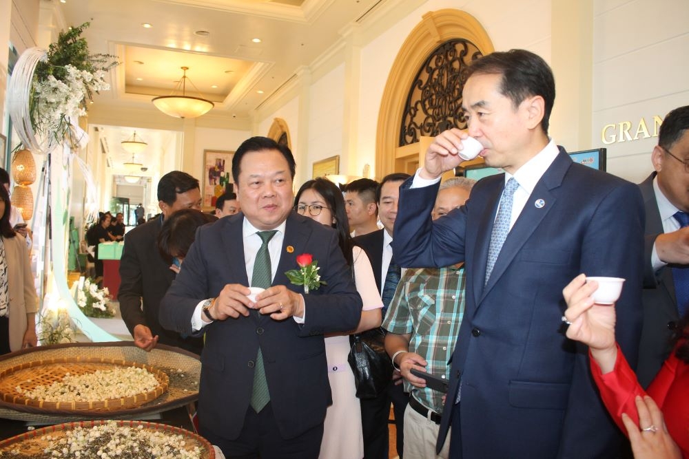 Đại sứ H&agrave; Vĩ (b&ecirc;n phải) v&agrave; &ocirc;ng Nguyễn Ho&agrave;ng Anh (b&ecirc;n tr&aacute;i) c&ugrave;ng thưởng tr&agrave; hoa nh&agrave;i. Ảnh CK.