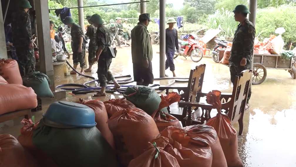 C&aacute;c chiến sỹ dọn dẹp b&ugrave;n đất gi&uacute;p b&agrave; con nh&acirc;n d&acirc;n tại x&atilde; Cẩm Mỹ