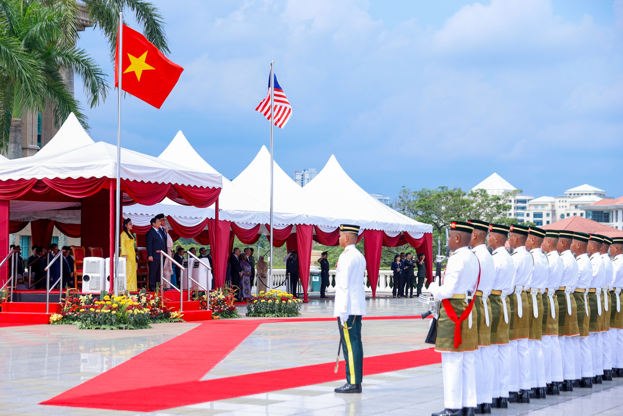 Khi hai Thủ tướng v&agrave; hai Phu nh&acirc;n đứng v&agrave;o vị tr&iacute; danh dự, dưới quốc kỳ hai nước, qu&acirc;n nhạc cử quốc thiều hai nước - Ảnh: VGP