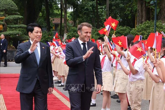 Chủ tịch nước Lương Cường và Tổng thống Pháp Emmanuel Macron với thiếu nhi Thủ đô Hà Nội - Ảnh: TTXVN