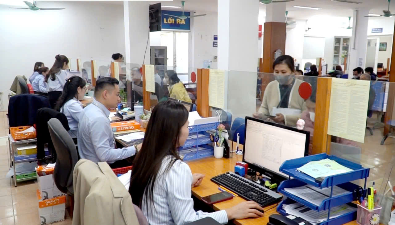 Công chức giải quyết thủ tục hành chính về bảo hiểm cho người dân. Ảnh: ND. 