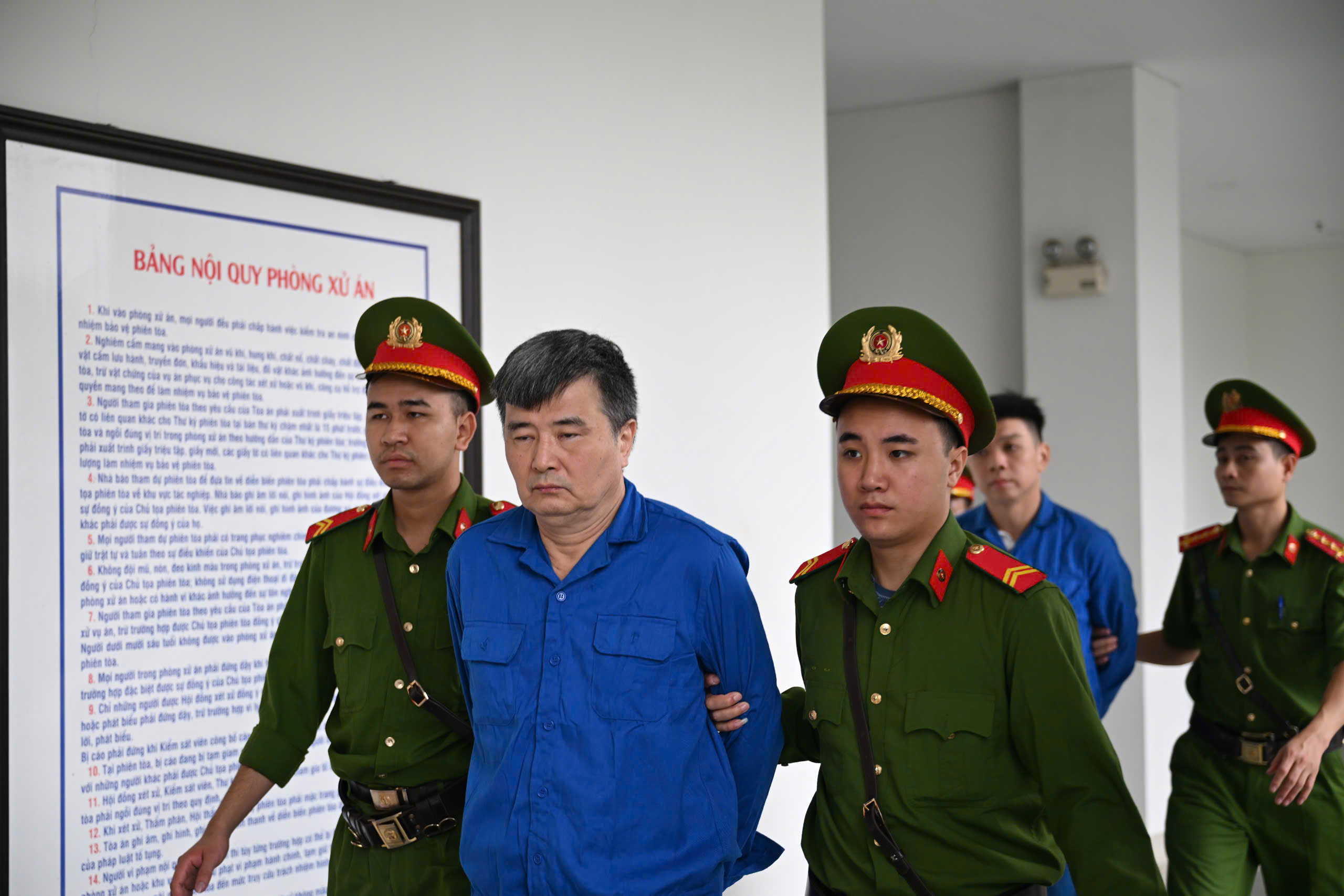 Cảnh sát dẫn giải các bị cáo đến tòa.