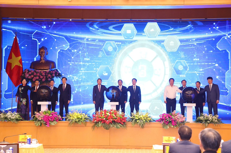 Thủ tướng Phạm Minh Chính, các Phó Thủ tướng và các đại biểu bấm nút khai trương Cổng Pháp luật quốc gia. Ảnh: MOJ.