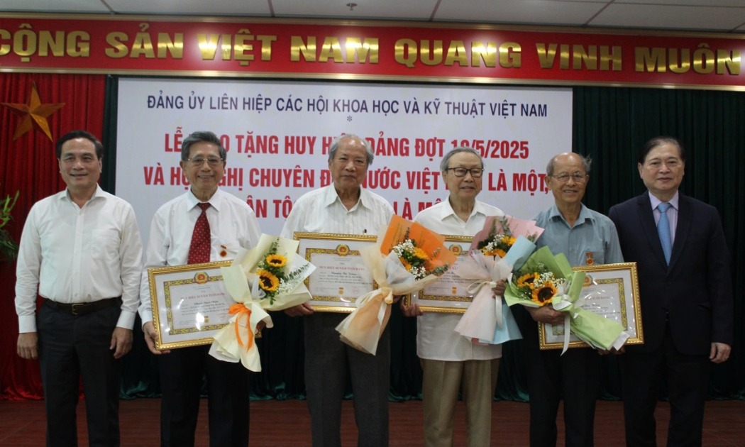 Bí thư Đảng ủy Phan Xuân Dũng và Phó Bí thư thường trực Đảng ủy Liên hiệp Hội Việt Nam Phạm Ngọc Linh trao huy hiệu cho các đảng viên.