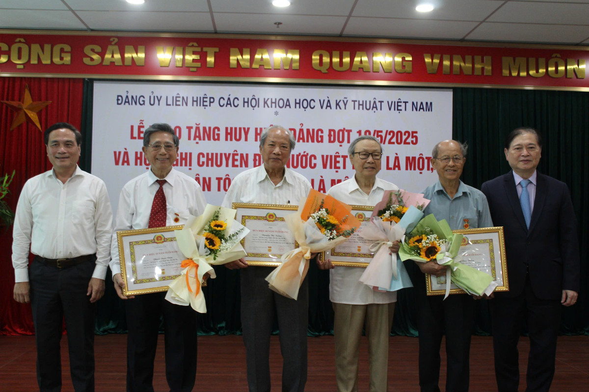 Bí thư Đảng ủy Phan Xuân Dũng và Phó Bí thư thường trực Đảng ủy Liên hiệp Hội Việt Nam Phạm Ngọc Linh trao huy hiệu cho các đảng viên.