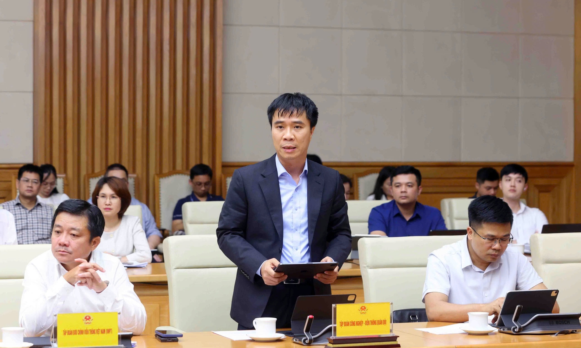 Đại diện Tập đoàn Công nghiệp-Viễn thông Quân đội (Viettel) giới thiệu ứng dụng trợ lý ảo hỏi đáp về phân cấp phân quyền và phân định thẩm quyền của địa phương 2 cấp - Ảnh: VGP/Nguyễn Hoàng