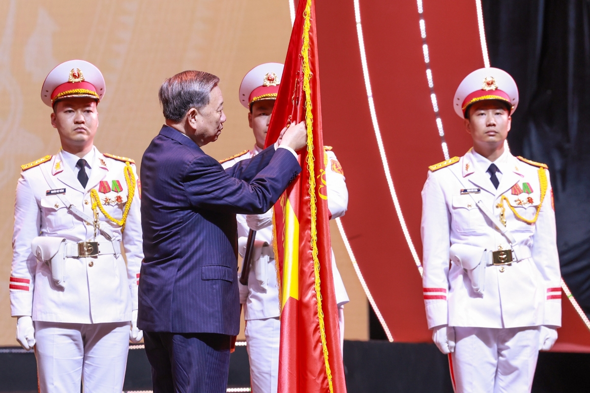 Tổng Bí thư Tô Lâm gắn Huân chương Hồ Chí Minh lên lá cờ truyền thống của Báo chí cách mạng Việt Nam. Ảnh: Trí Phong.