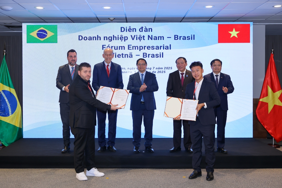 Thủ tướng Phạm Minh Ch&iacute;nh v&agrave; c&aacute;c đại biểu chứng kiến lễ trao thỏa thuận hợp t&aacute;c giữa C&ocirc;ng ty Cổ phần Nam Việt (NAVICO) v&agrave; AV09 Comercio Exporter Ltda trong lĩnh vực thủy sản. Ảnh: VGP.