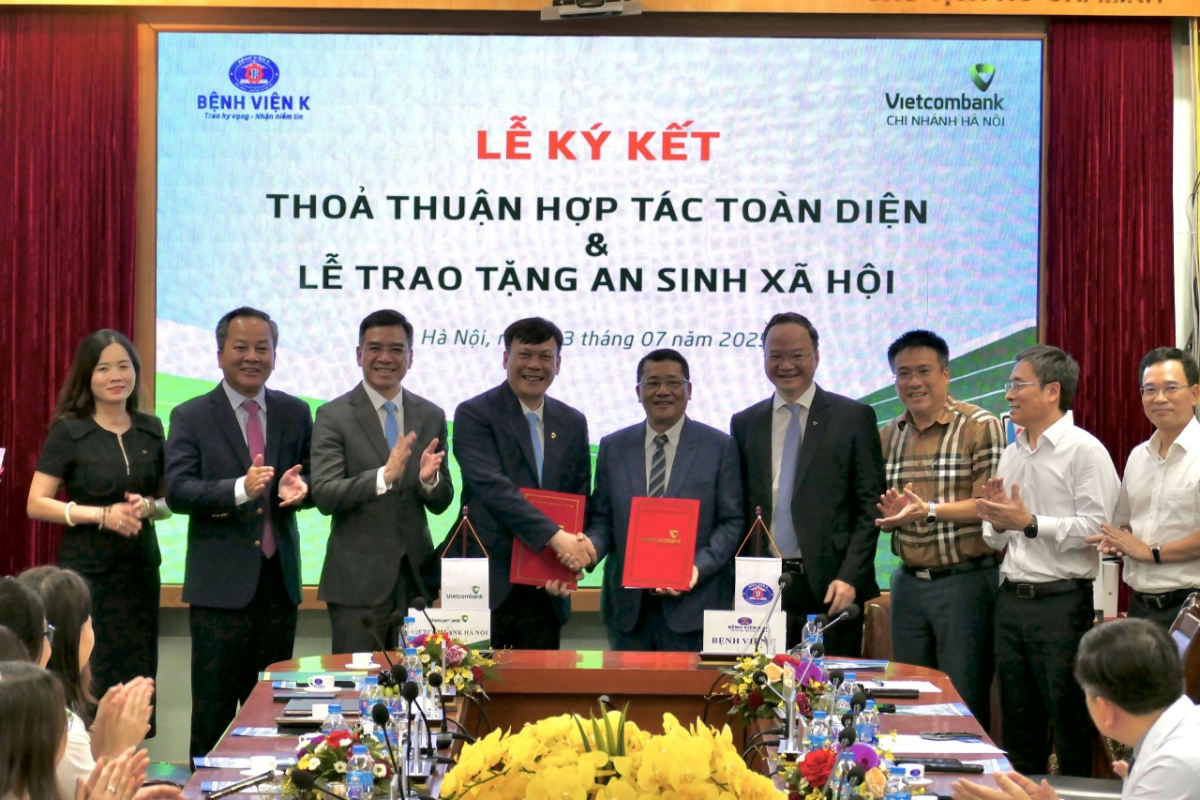 Ông Lê Văn Quảng - Giám đốc Bệnh viện K (thứ 5 phải qua) và ông Lê Ngọc Thái - Giám đốc Vietcombank Hà Nội (thứ 4 từ phải qua) đại diện hai đơn vị hoàn thành nghi thức ký kết thỏa thuận hợp tác trước sự chứng kiến của các đại biểu khách mời.