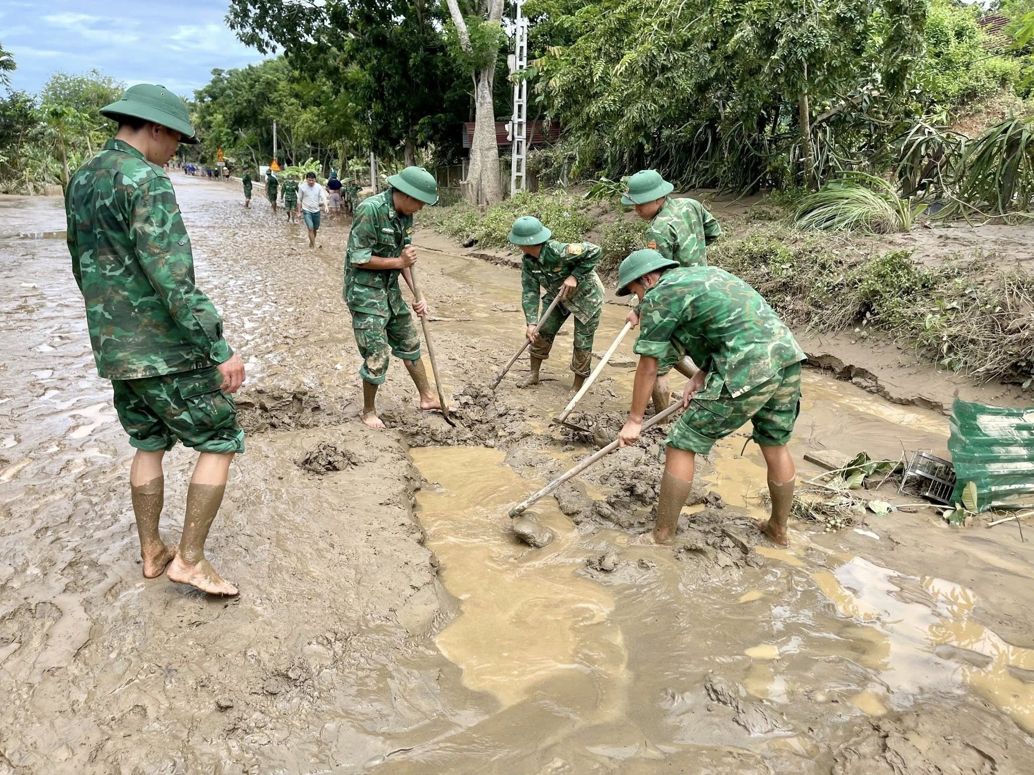 Các chiến sĩ bộ đội dọn bùn đất trên tuyến quốc lộ 7A đoạn qua xã Tam Thái