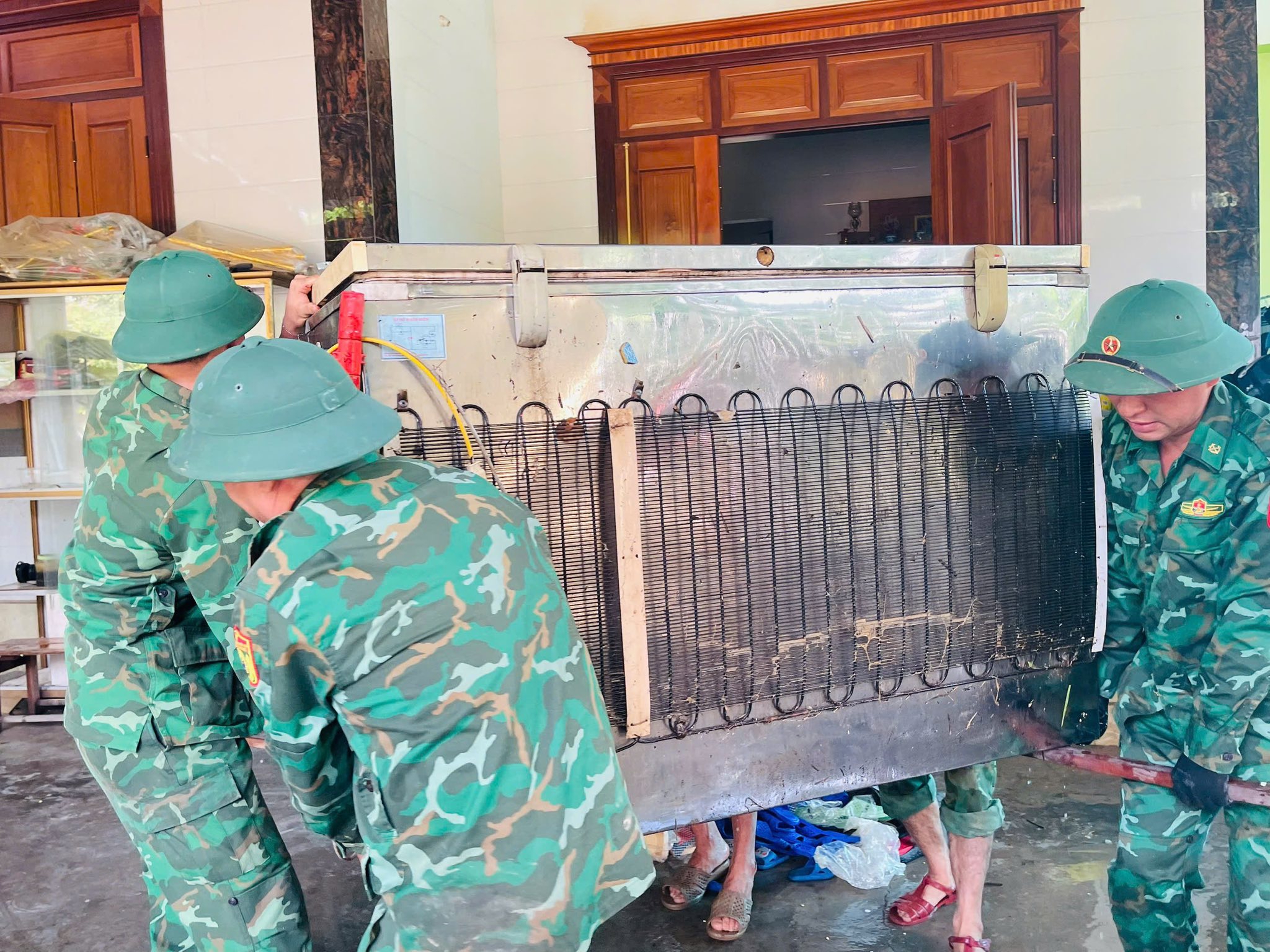 Các cán bộ, chiến sĩ đồn Biên phòng Tam Hợp dọn dẹp đồ đạc giúp người dân xã Tam Thái