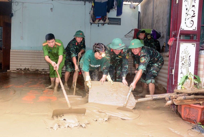 Cán bộ, chiến sĩ Ban chỉ huy Phòng thủ khu vực 4 - Tương Dương cùng các lực lượng giúp xã Con Cuông khắc phục hậu quả ngập lụt.