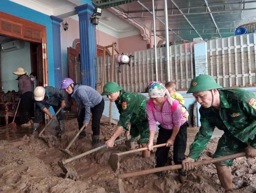 Bộ đội Đồn Biên phòng Cửa khẩu quốc tế Nậm Cắn (Nghệ An) giúp dân dọn nhà sau lũ.