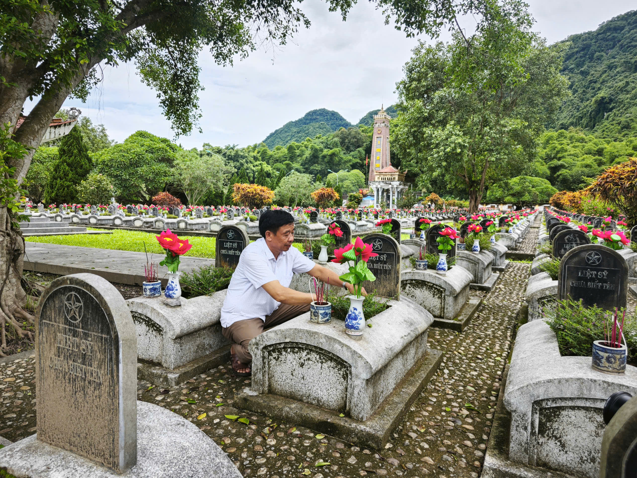 Ông Phạm Văn Nguyễn, người trông coi nghĩa trang, đang thắp hương trước các phần mộ liệt sĩ. Gắn bó với nghĩa trang gần 30 năm, ông Nguyễn xem việc chăm nom nơi này là một phần cuộc đời. “Nhiều người hy sinh mà chưa biết họ là ai. Mỗi lần dọn mộ, tôi cứ thấy day dứt,” ông nói.