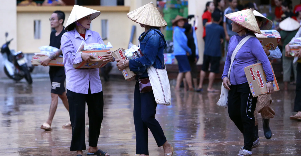 Người dân nhận hàng cứu trợ, phần nào vơi bớt khó khăn sau lũ lụt.