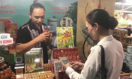 Khách hàng thanh toán bằng hình thức quét mã QR tại gian hàng sản phẩm đặc trưng địa phương. Ảnh Ngô Anh Văn