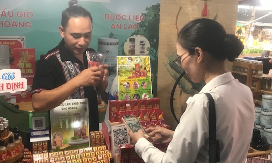 Khách hàng thanh toán bằng hình thức quét mã QR tại gian hàng sản phẩm đặc trưng địa phương. Ảnh Ngô Anh Văn