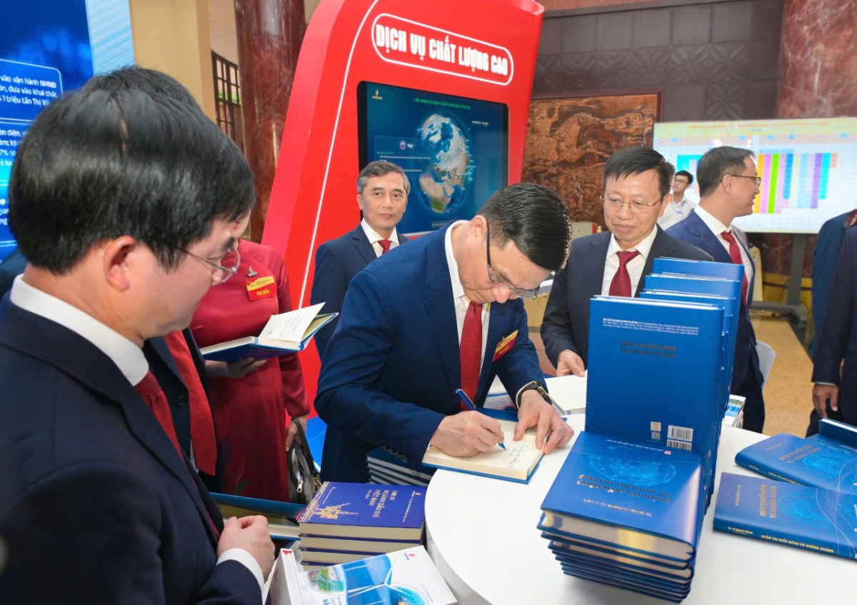 TS. Lê Mạnh Hùng ký tặng sách “Quản trị biến động và khủng hoảng” cho các đại biểu.