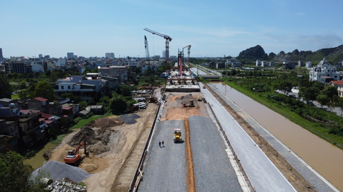 Đối với hạng mục đường dẫn đầu cầu: Ph&iacute;a bờ t&acirc;y đường sắt đ&atilde; thi c&ocirc;ng xong hạng mục tho&aacute;t nước, nền đường, đang triển khai thi c&ocirc;ng m&oacute;ng đường. Ph&iacute;a bờ đ&ocirc;ng đường sắt thuộc Đại lộ Đ&ocirc;ng T&acirc;y đ&atilde; thi c&ocirc;ng ho&agrave;n th&agrave;nh thi c&ocirc;ng cọc xi măng đất, đang thi c&ocirc;ng lớp gia cố đầu cọc xi măng đất
