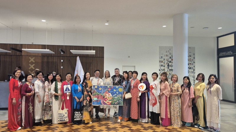 The delegation presents a handcrafted recycled silk artwork by Vụn Art to Amsterdam City Council as a symbol of gratitude and friendship.