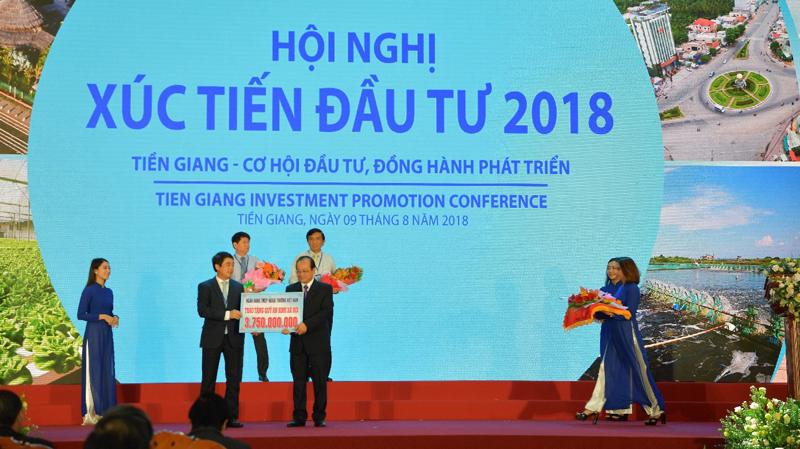 Ông Nghiêm Xuân Thành, Chủ tịch Hội đồng Quản trị Vietcombank (bên trái) trao tượng trưng số tiền 3,75 tỷ đồng của Vietcombank ủng hộ công tác an sinh xã hội tỉnh Tiền Giang.