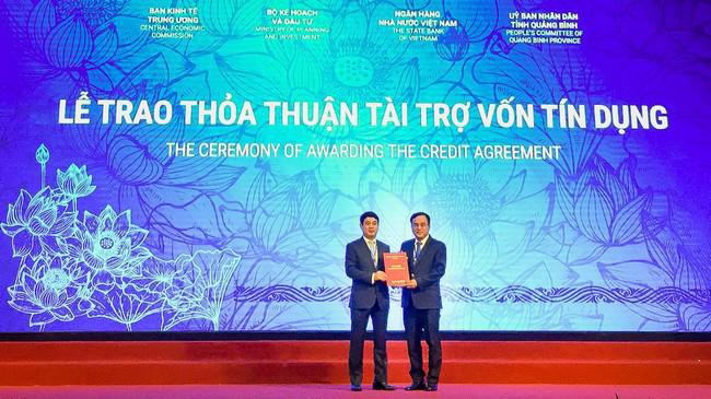 Đại diện Vietcombank, ông Nghiêm Xuân Thành - Chủ tịch Hội đồng Quản trị (bên trái) trao bản thỏa thuận nguyên tắc thu xếp vốn đối với dự án Nhà máy nhiệt điện Quảng Trạch 1 cho đại diện EVN.