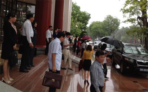 Các đại biểu Quốc hội lên xe trở về đoàn thảo luận lấy phiếu tín nhiệm trong trời mưa tầm tã, sáng 10/6 - Ảnh: NH.