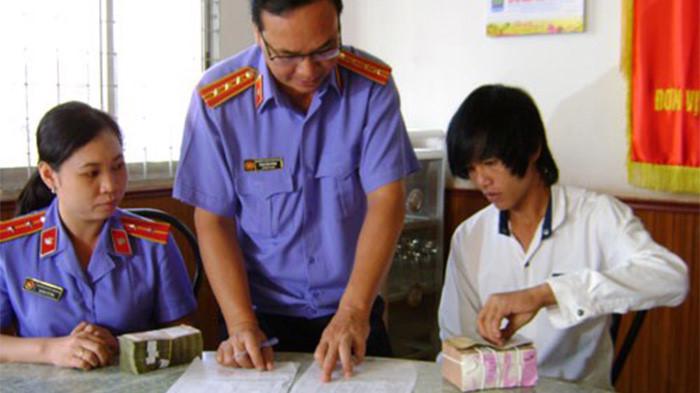 Đại diện Viện Kiểm sát nhân dân Sóc Trăng tiến hành thủ tục bồi thường oan sai cho một công dân - Ảnh: Phong Trinh.<br>