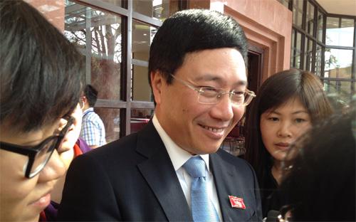 Tân Phó thủ tướng kiêm Bộ trưởng Bộ Ngoại giao Phạm Bình Minh trao đổi với các nhà báo bên hành lang Quốc hội sáng 13/11.
