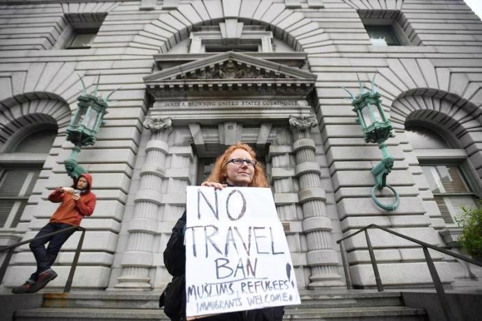 Một người biểu tình giơ biểu ngữ phản đối sắc lệnh cấm nhập cảnh của Tổng thống Donald Trump bên ngoài tòa án phúc thẩm ở Seattle hôm 7/2 - Ảnh: Reuters.<br>
