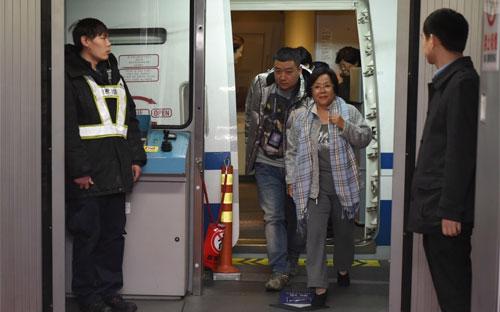 Bà Huang Yurong (giữa), một nhân vật trong danh sách 100 tham quan Trung Quốc lưu vong ở nước ngoài, đã tự nguyện về nước để chịu sự xét xử của pháp luật - Ảnh: SCMP.<br>