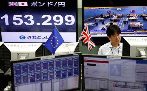 Một nhà giao dịch tiền tệ ở Tokyo theo dõi kết quả cuộc trưng cầu dân ý ở Anh hôm 24/6. Màn hình bên trái hiển thị tỷ giá đồng Bảng Anh so với Yên Nhật - Ảnh: Reuters/CNBC.<br>