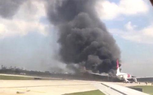 Chiếc máy bay của hãng Dynamic bị cháy động cơ ở sân bay Fort Lauderdale, Mỹ ngày 29/10 - Ảnh: Reuters.<br>