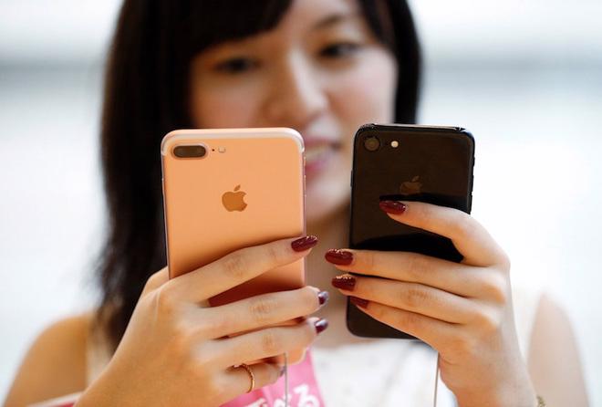 Một khách hàng nữ thử hai sản phẩm iPhone 7 và iPhone 7 Plus trong cửa 
hiệu Apple Store ở quận Omotesando, Tokyo, sáng 16/9 - Ảnh: Reuters.