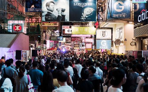 Du khách trên đường phố ở quận Mong Kok của Hồng Kông - Ảnh: Bloomberg.<br>