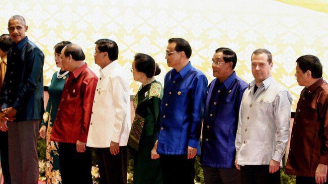 Tổng thống Mỹ Barack Obama (bìa trái) và Tổng thống Philippines Rodrigo Duterte (bìa phải) nhìn nhau khi đứng chụp ảnh cùng các nhà lãnh đạo khác tại thượng đỉnh ASEAN ở Lào - Ảnh: EPA/BBC.<br>
