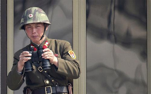 Một binh sỹ Triều Tiên đang theo dõi phía Hàn Quốc từ khu vực biên giới giữa hai miền hôm 4/4 - Ảnh: AP.<br>