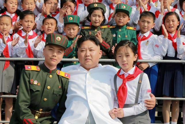 Nhà lãnh đạo Triều Tiên Kim Jong Un chụp ảnh cùng thiếu nhi nước này - Ảnh: KCNA/Reuters.<br>