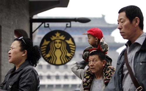 Người tiêu dùng bên ngoài một cửa hiệu của Starbucks ở Bắc Kinh - Ảnh: Reuters.<br>