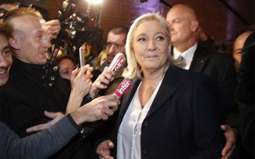 Bà Marine Le Pen, thủ lĩnh Đảng Mặt trận Quốc gia Pháp (FN) trong vòng vây của báo chí ngày 6/12 - Ảnh: Reuters.<br>