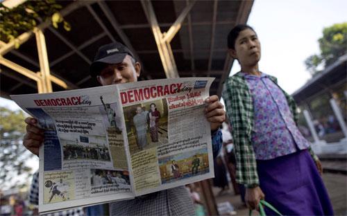 Một người dân ở Yangon, Myanmar đọc báo để cập nhật tin tức chính trị ở nước này ngày 3/12 - Ảnh: AP/WSJ.<br>