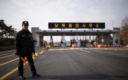 Một nhân viên bảo vệ đứng gác tại lối vào khu công nghiệp Kaesong hôm 11/2 - Ảnh: Reuters.<br>