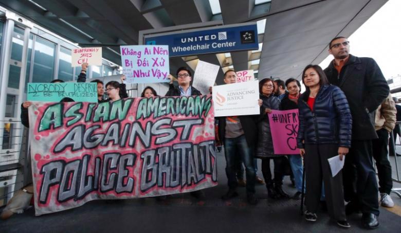 Người biểu tình phản đối việc United Airlines đối xử thô bạo với hành khách David Dao, tại sân bay quốc tế O'Hare, Chicago, Mỹ ngày 11/4 - Ảnh: Reuters.<br>