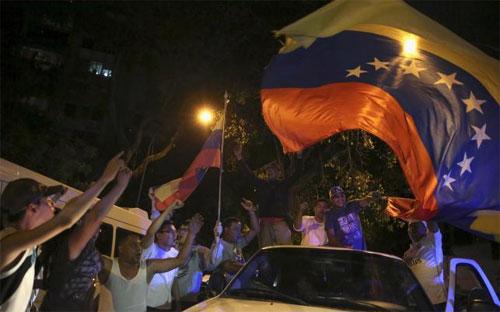 Người ủng hộ phe đối lập Venezuela ăn mừng chiến thắng bầu cử trên đường phố Caracas sáng sớm ngày 7/12 - Ảnh: Reuters.<br>