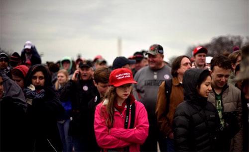 Một người ủng hộ Donald Trump đội chiếc mũ đỏ có khẩu hiệu "Make America Great Again" trong lễ nhậm chức Tổng thống của ông ở Washington ngày 20/1 - Ảnh: Reuters.<br>