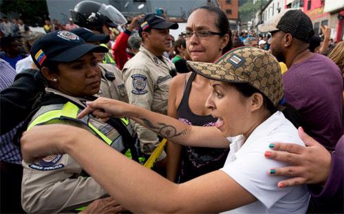 Người dân Venezuela đối mặt với cảnh sát trong một cuộc biểu tình đòi thức ăn - Ảnh: AP/ABC News.<br>