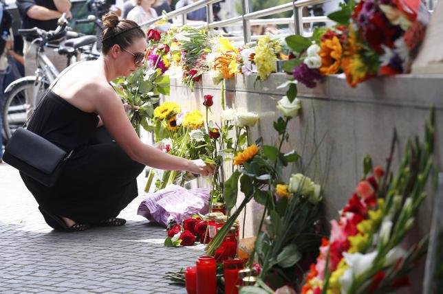 Người dân Munich đặt hoa tưởng niệm các nạn nhân vụ xả súng ngày 22/7 - Ảnh: Reuters.<br>
