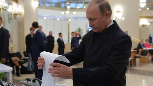 Tổng thống Nga Vladimir Putin đi bỏ phiếu trong cuộc bầu cử Quốc hội ngày 18/9 - Ảnh: AP/BBC.<br>