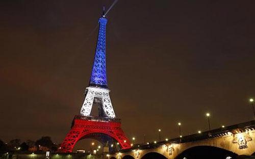 Tháp Eiffel thắp sáng bằng 3 màu trên quốc kỳ Pháp để tưởng nhớ các nạn nhân vụ khủng bố ở Paris hôm 13/11 - Ảnh: Reuters.<br>